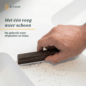 Hand using a Rithim cleaning tool on a surface