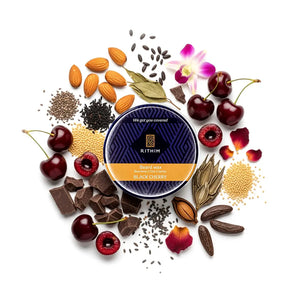 Rithim Black Cherry Beard Wax  surrounded by cherries, almonds, and other ingredients on a white background