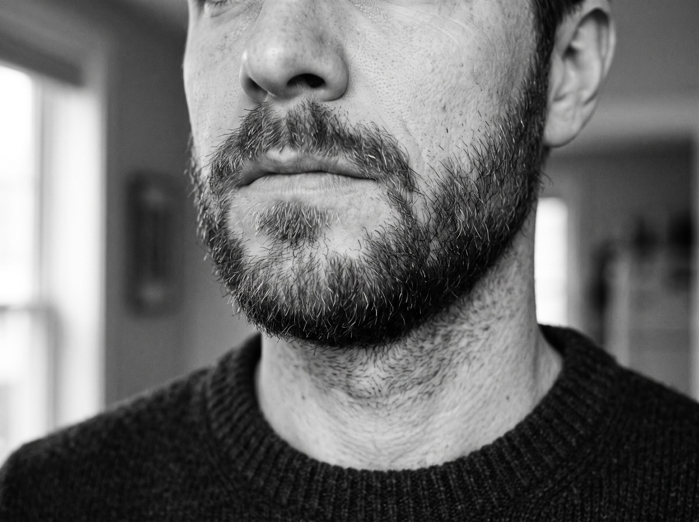 Close-up of a man with a neatly groomed short beard and a clean, defined neckline